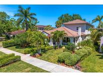 Charming home showcasing a tile roof, lush landscaping, and a welcoming front porch at 2421 Brevard Ne Rd, St Petersburg, FL 33704