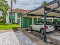 Carport with a beige Mini Cooper parked in front of green storage lockers and the building at 2555 Royal Pines Cir # A, Clearwater, FL 33763