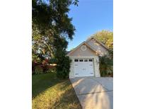 Charming home featuring a one-car garage, well-maintained lawn, and mature trees providing shade at 4504 Cabbage Palm Dr, Valrico, FL 33596