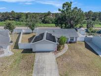 Aerial view of a single-story home with solar panels, fenced yard, and concrete driveway at 512 Red Mangrove Ln, Apollo Beach, FL 33572