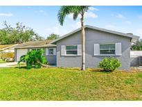 Charming single-story home featuring a well-maintained lawn and a gray exterior with white trim at 5519 Homewood Dr, Sarasota, FL 34232