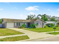 Charming single story home with well maintained lawn, mature trees, and a paved driveway leading to an attached garage at 5519 Homewood Dr, Sarasota, FL 34232