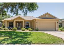 Charming single Gathering home with a lush green lawn, two-car garage, and a welcoming front porch at 9398 N Burnam Dr, Weeki Wachee, FL 34613