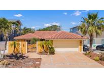 Charming single-story home with a terra cotta roof, stucco exterior, and a well-manicured yard with tropical landscaping at 1008 Mandalay Ave, Clearwater, FL 33767