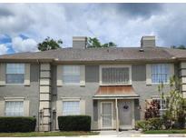 Inviting townhouse exterior featuring neutral tones, a charming front door, and well-maintained landscaping at 14061 Notreville Way, Tampa, FL 33624