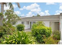 Charming condo featuring lush landscaping, a bright exterior, and a cozy courtyard at 1655 S Highland Ave # C155, Largo, FL 33756