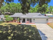 Charming one-story home with a well-manicured lawn, mature trees, and a two-car garage at 2204 Jennifer Ln, Valrico, FL 33594