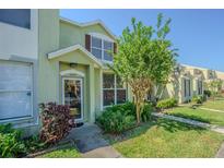 Charming townhome with well-maintained landscaping and a welcoming front entrance with a glass storm door at 6343 Osprey Lake Circle, Riverview, FL 33578