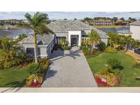Stunning waterfront home boasts lush landscaping, a spacious driveway, and a grand entrance at 813 Manns Harbor Dr, Apollo Beach, FL 33572