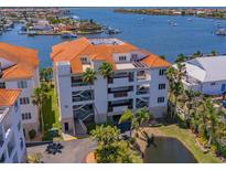 Multi-story waterfront condo with orange tile roof, balconies, and tropical landscaping at 1042 Bellasol Way # 202, Apollo Beach, FL 33572
