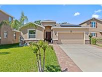 Charming single-story home with well-manicured lawn, stone accents, and a two-car garage at 10514 Scenic Hollow Dr, Riverview, FL 33578