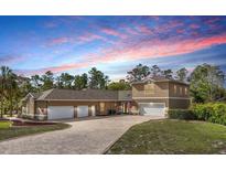 Stunning two-story home with a brick driveway and a three-car garage, offering ample parking and curb appeal at 11296 Warm Wind Way, Weeki Wachee, FL 34613