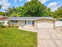 Charming single-story home featuring a well-maintained lawn, attached garage, and inviting front entrance at 1390 S Hillcrest Ave, Clearwater, FL 33756