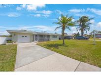 Charming single-story home featuring a one-car garage, screened porch, and well-maintained lawn under a bright blue sky at 1410 Lime St, Clearwater, FL 33756