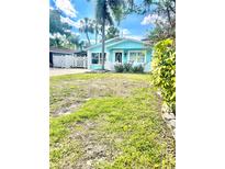 Charming blue bungalow with a white picket fence and well-manicured landscaping at 1734 Maryland Ne Ave, St Petersburg, FL 33703