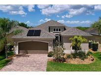 Charming single-story home featuring a brick driveway, two-car garage, and well-maintained landscaping at 1803 Pacific Dunes Dr, Sun City Center, FL 33573