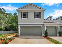 Charming two-story townhome featuring an attached garage, neutral paint, and well-manicured landscaping at 2531 Earlswood Ct, Brandon, FL 33510