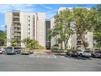 The exterior of the building shows well-maintained grounds, mature trees, and dedicated parking at 2699 Seville Blvd # 705, Clearwater, FL 33764