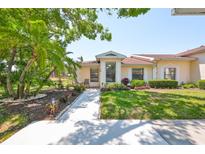 Charming single-story home featuring lush landscaping and a welcoming front walkway leading to the front door at 319 Kelsey Way, Sun City Center, FL 33573
