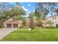 Charming single-Gathering home featuring a well-manicured lawn and an attached two-car garage at 3215 W Fair Oaks Ave, Tampa, FL 33611