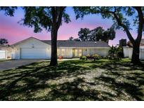 Charming home with a manicured lawn, mature trees and lovely landscaping at 4368 Marine Pkwy, New Port Richey, FL 34652