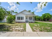 Charming home with white siding, dark shutters, a well-manicured lawn and mature trees at 4568 18Th S Ave, St Petersburg, FL 33711