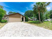 Charming single-story home with a stone accent wall and a spacious paved driveway at 5298 Florentine Ct, Spring Hill, FL 34608