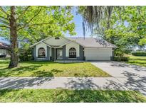 Charming single-story home featuring a manicured lawn and a two-car garage at 6302 Silver Oaks Dr, Zephyrhills, FL 33542