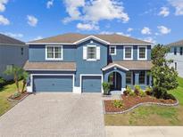 Stunning two-story home with a three-car garage and beautifully landscaped front yard at 11852 Lake Lucaya Dr, Riverview, FL 33579