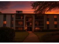Beautiful multi-story condo building with balconies and landscaped lawn during a sunset at 1309 Pine Ridge E Cir # D3, Tarpon Springs, FL 34688