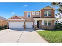 Two-story stucco home featuring an attached three-car garage and a well-manicured lawn in a suburban neighborhood at 15608 Starling Water Dr, Lithia, FL 33547