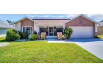 Charming single-story home with a well-maintained lawn, stone accents, and an attached garage at 1575 Wicklow Dr, Palm Harbor, FL 34684