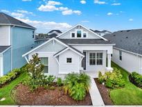 Charming one-story home featuring a well-manicured lawn and inviting front porch at 28680 Cozy Creek Dr, Wesley Chapel, FL 33543
