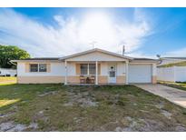 Cozy single-Gathering home with a well-lit front porch, single car garage, and mature tree providing shade at 3706 Cambridge St, New Port Richey, FL 34652