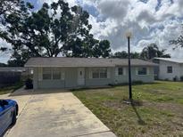 Charming single-story home featuring a concrete driveway, light blue siding, and a well-maintained front yard at 5806 Beech St, Zephyrhills, FL 33542