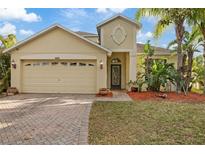 Charming single-Gathering home with manicured lawn, brick driveway, and inviting entryway at 8429 Hunters Fork Loop, Ruskin, FL 33573