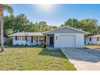Charming single-story home with a well-maintained lawn, a bright, white exterior and a one car garage at 10137 Oleander Dr, Port Richey, FL 34668