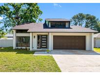 Charming single-Gathering home with modern door, attached garage and well manicured front lawn at 15307 Summerwind Dr, Tampa, FL 33624