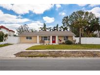Charming single-story home with a well-maintained lawn, palm trees and a brick driveway at 1820 Massachusetts Ne Ave, St Petersburg, FL 33703