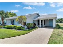 Charming single-story home with a well-manicured lawn, vibrant landscaping, and a covered carport at 2313 Grenoble Pl # 2313, Sun City Center, FL 33573