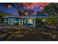 Charming blue two-story home featuring a pergola-covered entrance and well-maintained front yard at 5153 Bay Blvd, Port Richey, FL 34668