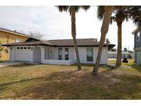 Charming single-story home featuring a fresh white paint job and a two-car garage at 7534 Mako Dr, Hudson, FL 34667