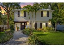 Charming two-story home featuring a manicured front yard, paver walkway, and inviting entrance at 8020 Sharon Dr, Tampa, FL 33617