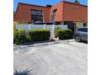 Two-story townhome featuring a red tile roof, balcony, and white fence at 8119 Oak Trace Way # C, Tampa, FL 33634
