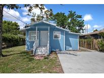 Charming blue single-story home with a well-manicured lawn and a concrete driveway at 8624 N Semmes St, Tampa, FL 33604