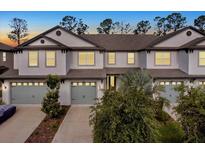 Charming townhome featuring a two-car garage, well-maintained landscaping, and a welcoming front entrance at 11443 Cay Spruce Way, San Antonio, FL 33576