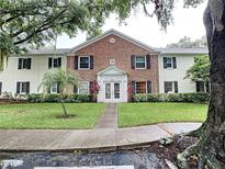 Inviting two-story condo complex with manicured lawn and lush landscaping around the front walkway entrance at 13833 Orange Sunset Dr # 201, Tampa, FL 33618