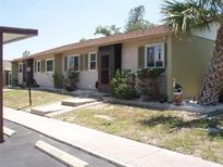 Inviting tan condominium with a screen door and well-maintained landscaping at 1942 Settlement Rd # 25, Venice, FL 34285