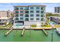 A beautiful view of the building exterior, including the pool, dock, and waterway at 211 Dolphin Pt # 403, Clearwater Beach, FL 33767