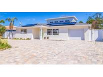 Charming single-Gathering home showcasing a well-manicured lawn and a paved driveway at 233 45Th Ave, St Pete Beach, FL 33706